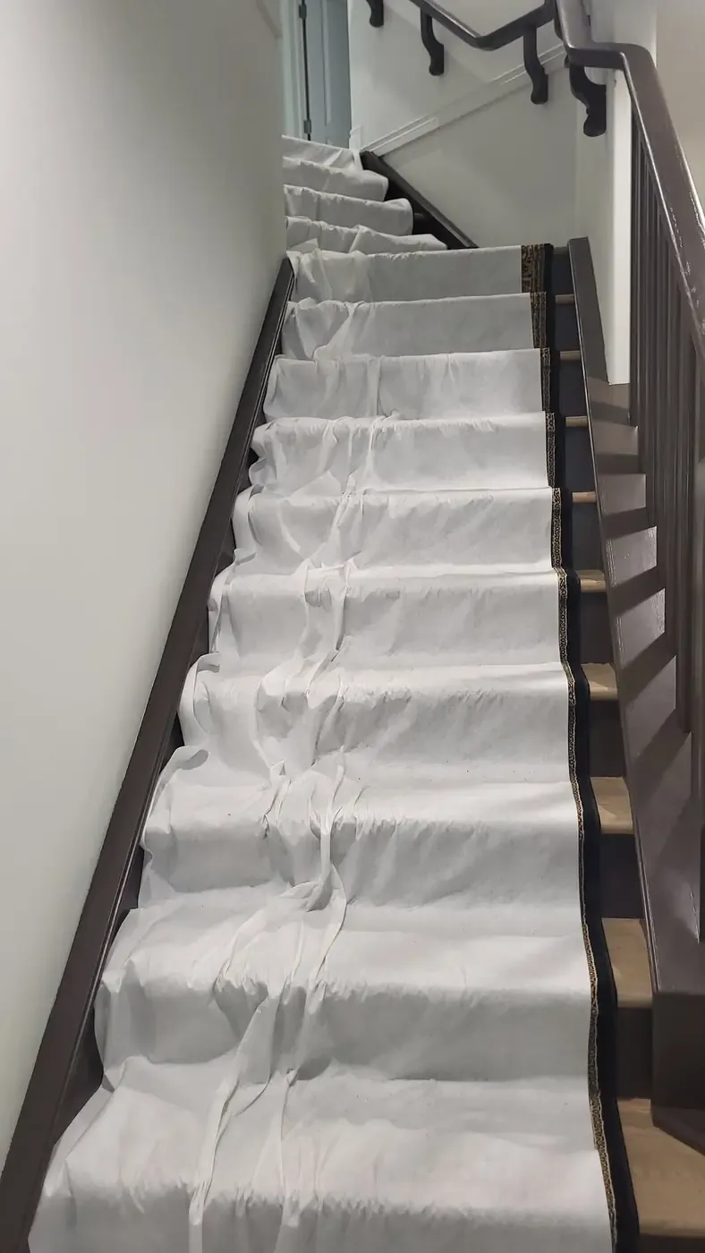 Stairs covered with drop cloths before equipment is carried through the house